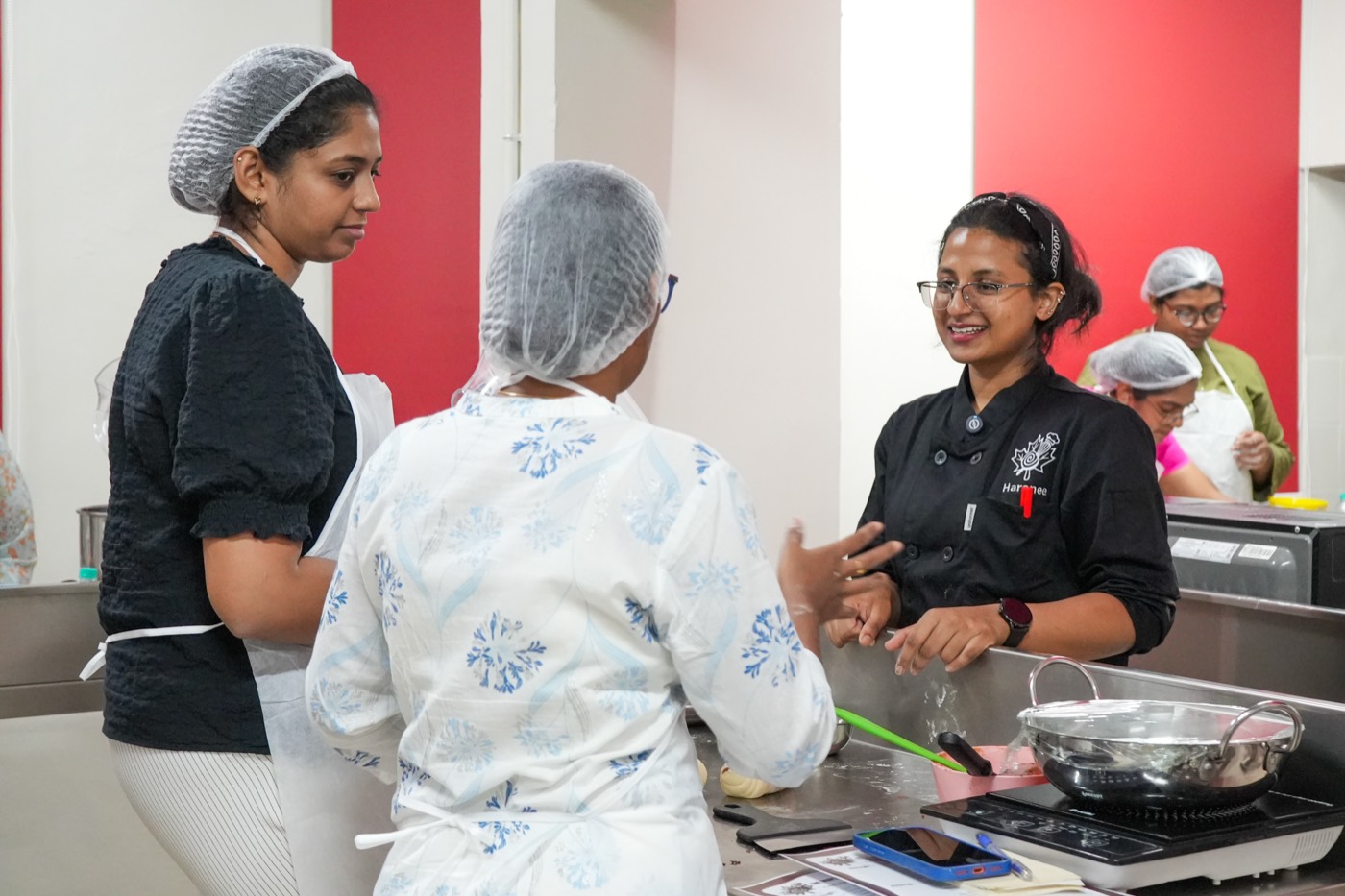 Chef and students at the counter in the Maple Academy kitchen